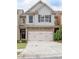 Inviting townhome with a two-car garage, stone detailing, and lush greenery at 2243 Knoxhill Se Vw, Smyrna, GA 30082