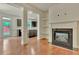 Open-concept living room with hardwood floors and a cozy fireplace featuring white mantle and built-in shelving at 2243 Knoxhill Se Vw, Smyrna, GA 30082