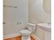 Simple powder room with a pedestal sink, wood floor, and a modern mirror at 2243 Knoxhill Se Vw, Smyrna, GA 30082