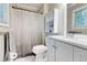 Bathroom featuring white cabinets, a shower with a curtain, and a window with blinds at 3861 Hanover Ct, Marietta, GA 30062