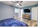 Bedroom with blue walls, wood floors, a ceiling fan, and a TV on the wall at 3861 Hanover Ct, Marietta, GA 30062