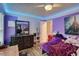 Bedroom with purple walls, wood floors, a ceiling fan, and a mirror above a dark wood dresser at 3861 Hanover Ct, Marietta, GA 30062