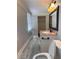 Bright bathroom featuring gray wood-look flooring, a marble sink, and vanity with a modern mirror at 1055 Worthington Hills Dr, Roswell, GA 30076