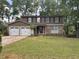 Two-story home with stone and siding, two-car garage, and a well-manicured front lawn at 1055 Worthington Hills Dr, Roswell, GA 30076