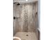 Tiled shower with decorative accent, rainfall shower head, and glass door in renovated bathroom at 1055 Worthington Hills Dr, Roswell, GA 30076