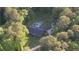 Wide aerial view of the home, showcasing the surrounding greenery, pool, and extended driveway at 160 Riverbrooke Trl, Covington, GA 30016
