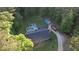 Aerial view of the property showcasing the house, in-ground pool, surrounding trees, and driveway at 160 Riverbrooke Trl, Covington, GA 30016
