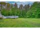 Large backyard with a deck leading to the above ground pool and mature landscaping at 160 Riverbrooke Trl, Covington, GA 30016