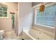 Bathroom featuring a soaking tub, large window and patterned flooring at 160 Riverbrooke Trl, Covington, GA 30016