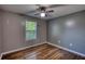 Bright bedroom with hardwood floors, a ceiling fan, and a large window overlooking the backyard at 160 Riverbrooke Trl, Covington, GA 30016