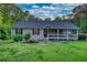Charming single-story home with a welcoming front porch, complemented by a lush lawn and serene pond feature at 160 Riverbrooke Trl, Covington, GA 30016