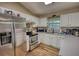 Well-lit kitchen featuring stainless steel appliances and white cabinets at 160 Riverbrooke Trl, Covington, GA 30016
