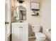 A well-lit half bathroom featuring modern fixtures, decorative mirror, and a toilet at 1928 Stancrest Nw Trce, Kennesaw, GA 30152