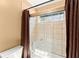 Clean shower-tub combination with tiled walls, glass doors, and neutral colored curtain at 300 Morganshire Pl, Atlanta, GA 30350