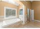 Bright bathroom showcasing a tiled tub with jets, a window, and a glass door shower with an accent column at 300 Morganshire Pl, Atlanta, GA 30350
