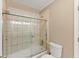 Clean bathtub and shower combination featuring ceramic tile, glass shower doors and a neutral paint scheme at 300 Morganshire Pl, Atlanta, GA 30350