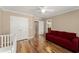 Bright bedroom with hardwood floors, red couch, and white closet doors at 300 Morganshire Pl, Atlanta, GA 30350