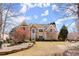 A stately two-story home with a stone and stucco facade, landscaped garden, and a well-manicured lawn at 300 Morganshire Pl, Atlanta, GA 30350