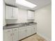 Kitchenette featuring white cabinets, gray countertops, stainless steel sink and tile floor at 300 Morganshire Pl, Atlanta, GA 30350