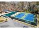An aerial view of community tennis courts and swimming pool enclosed by mature trees and fencing at 300 Morganshire Pl, Atlanta, GA 30350
