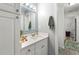 Bright bathroom with white vanity, decorative mirror, and storage at 4131 N Gloucester Pl, Atlanta, GA 30341