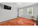 Bright bedroom featuring wood floors, a large rug, and modern wall-mounted TV at 4131 N Gloucester Pl, Atlanta, GA 30341