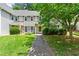 Charming two-story townhouse featuring a well-maintained lawn, mature trees, and neutral-toned siding at 4131 N Gloucester Pl, Atlanta, GA 30341