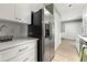 Updated kitchen with stainless steel refrigerator, white cabinets, and a view to a hallway at 4131 N Gloucester Pl, Atlanta, GA 30341