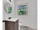 Renovated bathroom with modern vanity, decorative floor tiles, and an eye-catching round mirror at 644 Church Nw St, Atlanta, GA 30318