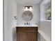Stylish bathroom featuring a modern vanity with a round mirror, and vanity lighting at 644 Church Nw St, Atlanta, GA 30318