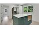 Kitchen with an island, quartz countertop, dark green cabinets and stainless steel refrigerator at 644 Church Nw St, Atlanta, GA 30318