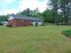 Expansive backyard of a charming brick home with a well-maintained lawn and mature trees at 126 Brittany Dr, Canton, GA 30115