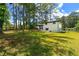 Expansive backyard with green grass, a white house, and a patio at 1934 Glen Echo Dr, Decatur, GA 30032