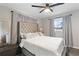 This is a bedroom with a tufted headboard, ceiling fan, and neutral decor at 1934 Glen Echo Dr, Decatur, GA 30032