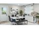 Modern dining area features a sleek white table, gray chairs and bench, complemented by stylish decor at 1934 Glen Echo Dr, Decatur, GA 30032