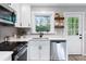 Beautiful kitchen with stainless steel appliances, bright white cabinets, and a view of the backyard at 1934 Glen Echo Dr, Decatur, GA 30032