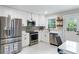 Bright kitchen featuring stainless steel appliances, white cabinets, and a view to the backyard at 1934 Glen Echo Dr, Decatur, GA 30032