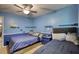 Bright bedroom showcasing two beds, a ceiling fan, and open wall shelves for decor at 2368 Ellis Court, Snellville, GA 30078