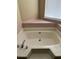 This bathroom showcases a soaking tub with a tile surround under a window at 432 Manor Estates Dr, Stockbridge, GA 30281