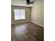 Bright, neutral bedroom featuring a large window, ceiling fan, and luxury vinyl plank flooring at 432 Manor Estates Dr, Stockbridge, GA 30281