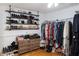 Walk-in closet with custom shelving for shoes, hanging clothes, and a dresser at 762 Thompson Ln, Loganville, GA 30052