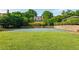 Community basketball court with green surface, surrounded by lush lawn and mature trees at 9056 Riverbend Mnr, Alpharetta, GA 30022