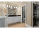 Bathroom featuring a double vanity with dark countertops and tiled floors, and a doorway to toilet at 9056 Riverbend Mnr, Alpharetta, GA 30022