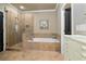 Elegant bathroom with soaking tub, frameless shower, and neutral tile surround at 9056 Riverbend Mnr, Alpharetta, GA 30022