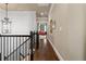 Upper hallway with hardwood floors, elegant lighting, and access to various rooms at 9056 Riverbend Mnr, Alpharetta, GA 30022