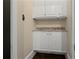 A bright laundry room with white cabinets, granite countertop, and dark hardwood floors at 9056 Riverbend Mnr, Alpharetta, GA 30022