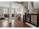 Inviting living room with hardwood floors, comfortable seating, and a classic staircase with a safety gate at 9056 Riverbend Mnr, Alpharetta, GA 30022