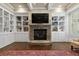 Comfortable living room featuring a stone fireplace, built-in shelving, and hardwood floors at 9056 Riverbend Mnr, Alpharetta, GA 30022
