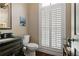Half bath with dark vanity, black countertop, and white shutters at 9056 Riverbend Mnr, Alpharetta, GA 30022