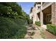 Landscaped walkway between brick building and thick green bushes in a bright outdoor setting at 9056 Riverbend Mnr, Alpharetta, GA 30022